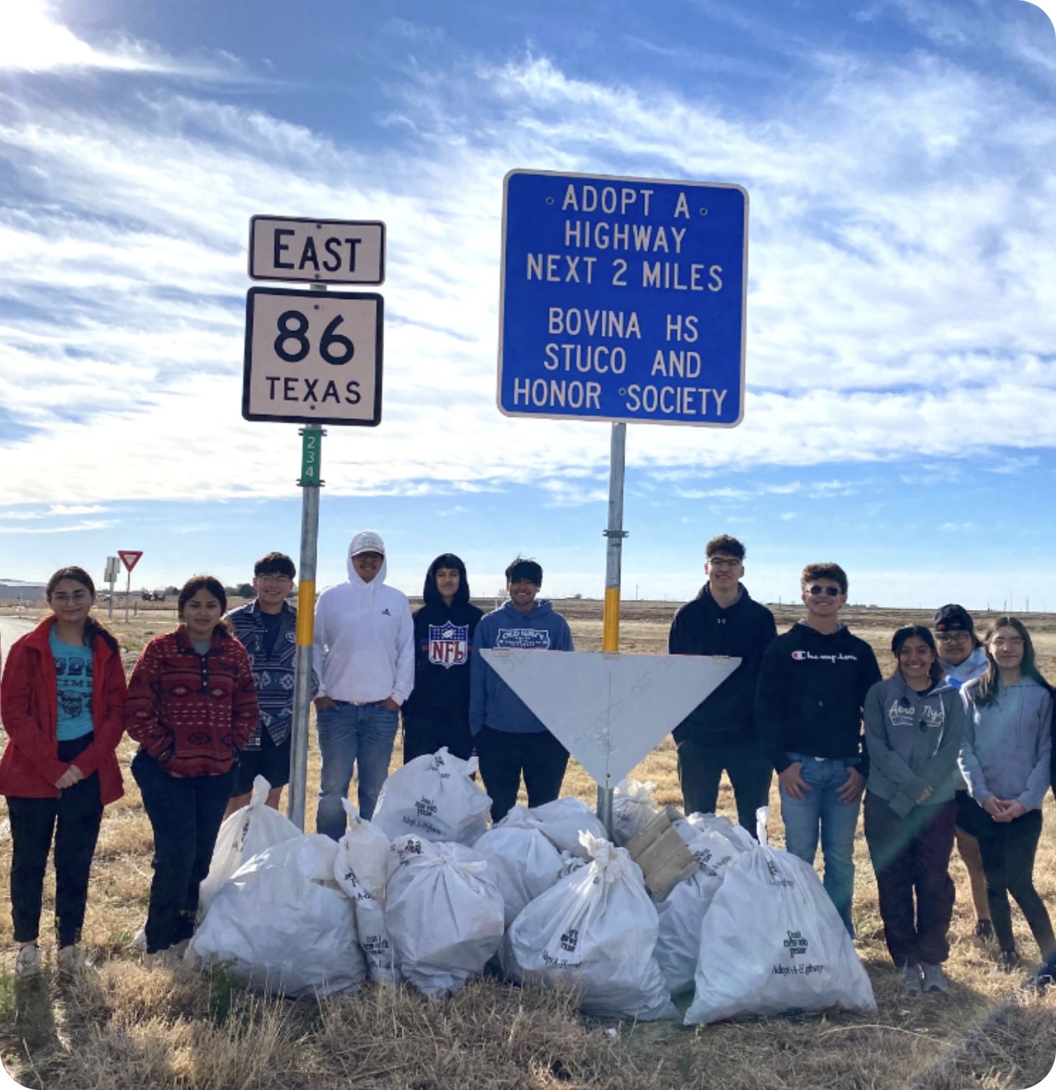 "Bovina HS Stuco and Honor Society" volunteers pose in front of the trash bags they have picked up on Texas State Highway 86 East.